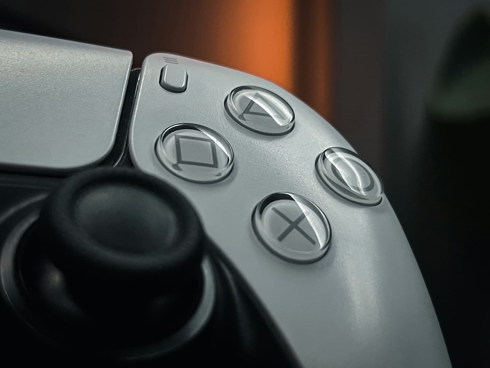 Gros plan sur le joystick droit et les quatre boutons d’une manette DualSense blanche